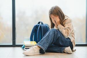 Bullying, discrimination or stress concept. Sad teenager crying in school photo