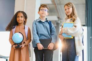 Group of elementary school kids in a school corridor photo