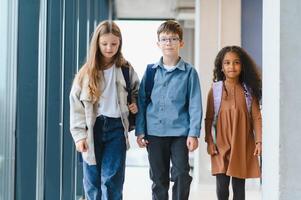 Portrait of smiling little school kids in school corridor photo