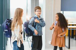 Portrait of smiling little school kids in school corridor photo