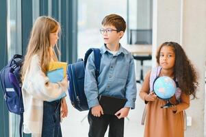 grupo de elemental colegio niños en un colegio corredor foto