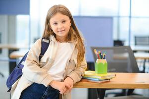 linda pequeño Chica de escuela en salón de clases foto