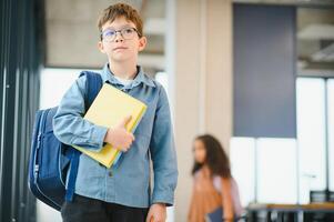 Schoolboy with schoolbag and books in the school. Back to school photo