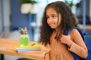 African-American girl in school looking at camera while standing in classroom, copy space photo