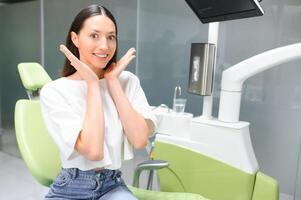 sonriente y satisfecho paciente en un dental oficina después tratamiento foto