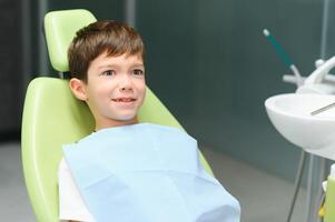 Surprised little boy sitting in the dentist's chair photo