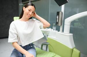 Smiling and satisfied patient in a dental office after treatment photo