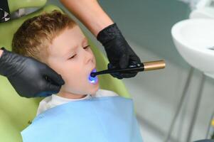 Scared red-haired boy crying at reception at dentist in dental chair. Pediatric dentistry photo