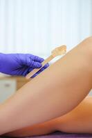 Sugaring epilation with liquate sugar at legs photo