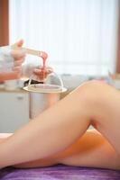 Sugaring epilation with liquate sugar at legs photo