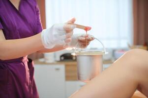 Close up waxing in by a beautician in a spa center photo