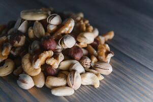 mixed nuts in a bowl on wooden table, top view with copy space. photo