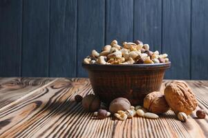 mixed nuts in a bowl on wooden table, top view with copy space. photo