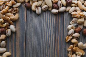 Mixed nuts on wood floor. Organic and fresh nuts. Copy space photo