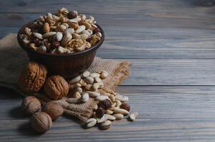 Mixed nuts on wood floor. Organic and fresh nuts. Copy space photo