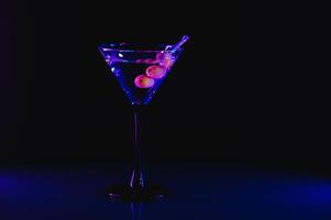 Drink martini. Martini with olives on a black table. Free space for text. photo