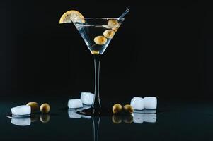 bebida martini. martini con aceitunas en un negro mesa. gratis espacio para texto. foto