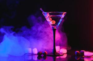 Martini cocktail drink splash with ice cubes in neon iridescent pink and blue colors. Minimal night party life concept. photo