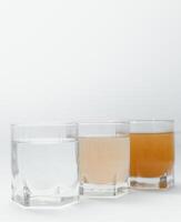 Water filters. Concept of three glasses on a white background. Household filtration system. photo