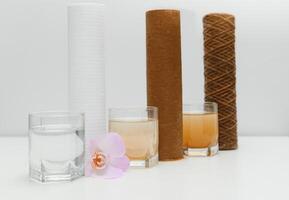 Water filters. Concept of three glasses on a white background. Household filtration system. photo