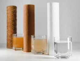 Water filters. Concept of three glasses on a white background. Household filtration system. photo