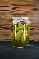 Pickled cucumbers in the jar. Ingredients for pickling cucumbers. Cucumbers, dill, garlic. Glass jars with pickles photo