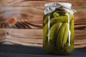 Pickled cucumbers in the jar. Ingredients for pickling cucumbers. Cucumbers, dill, garlic. Glass jars with pickles photo