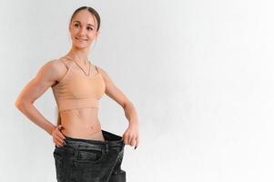 A slim woman is showing how much weight she lost photo