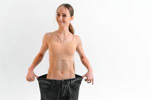 A slim woman is showing how much weight she lost photo