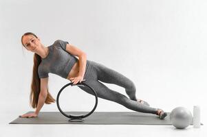 Sexy young female doing exercise on isolated white background photo