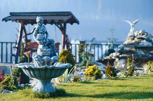 Fountain in the park garden. Water flows from the fountain. photo