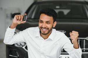 Happy indian man showing the key of his new car photo