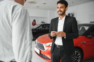 indian cheerful car salesman at showroom. photo