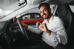 Happy indian man showing the key of his new car photo