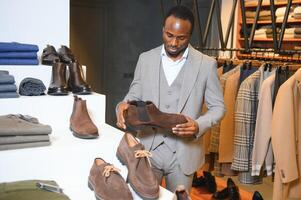 joven hermoso hombre elegir Zapatos a un tienda foto