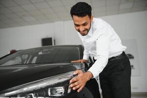 happy indian man checking car features at showroom photo