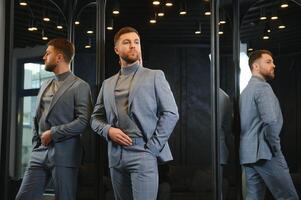 Smiling man trying on suit at mirror in menswear shop photo