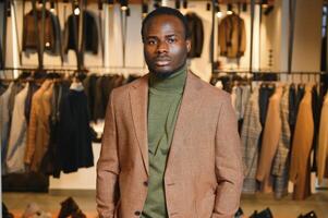 A handsome young african gentleman buying an elegant suit photo