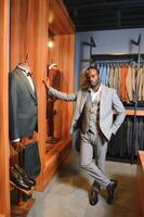 A handsome young african gentleman buying an elegant suit photo