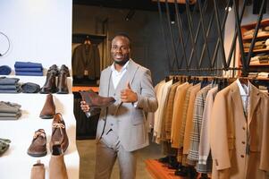 joven hermoso hombre elegir Zapatos a un tienda foto