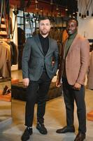 dos hermoso respetable hombres en elegante clásico trajes en un prima de los hombres ropa Tienda foto