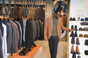 Young african man shopping in clothing store photo