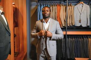 A handsome young african gentleman buying an elegant suit photo