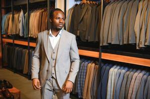 A handsome young african gentleman buying an elegant suit photo