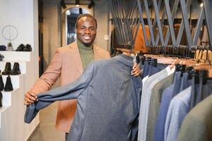 African Businessman in classic suit against row of suits in shop photo