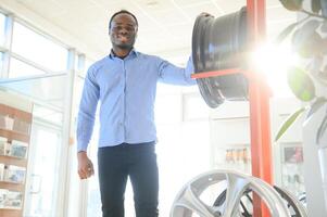 An African man buys car rims in an auto parts store photo