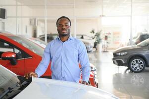 Car Buyer. Black Guy Choosing New Automobile In Dealership Store photo