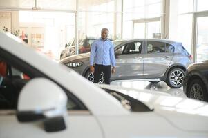 coche comprador. negro chico elegir nuevo automóvil en concesión Tienda foto