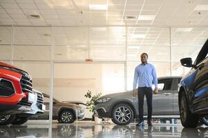 Car Buyer. Black Guy Choosing New Automobile In Dealership Store photo