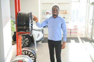 An African man buys car rims in an auto parts store photo